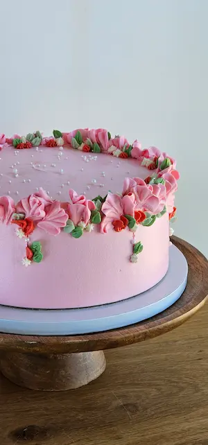 Pink cake with buttercream flowers and pearls