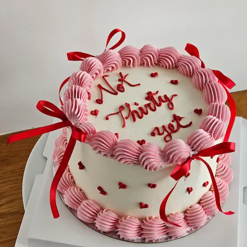Pink vintage birthday cake with red bows