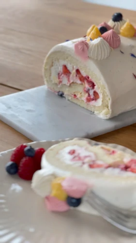 Berry roll cake slice with fresh fruit
